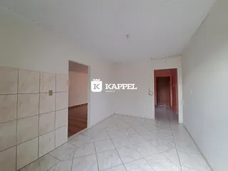 Hall de entrada com piso de porcelanato claro e paredes brancas.