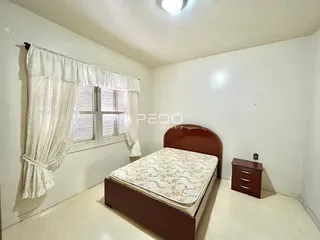 Quarto com cama de madeira e janela decorada em Lajeado.