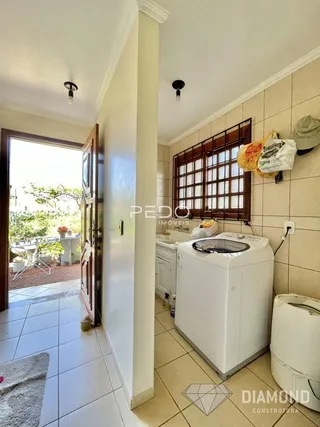 Hall de entrada com piso de cerâmica e porta de madeira em uma residência.