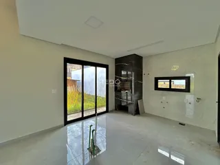 A sala de estar apresenta paredes brancas e piso claro.