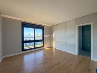 Sala de estar com piso de madeira e grande janela de vidro.
