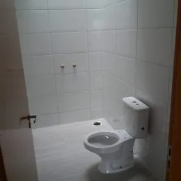 Banheiro com revestimento de azulejos brancos.