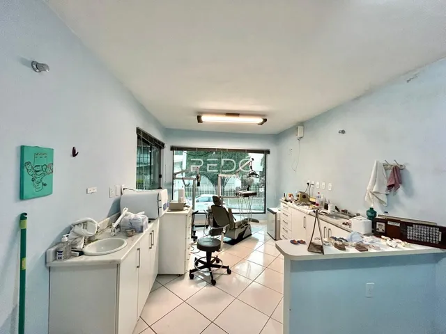Foto de um banheiro com bancada branca e piso claro em uma residência.