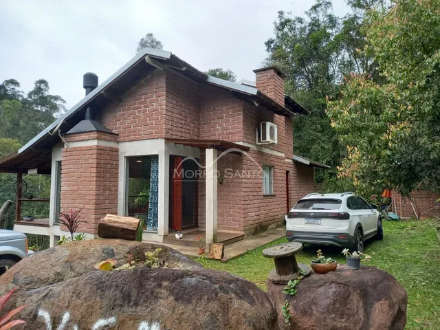 Fachada de casa de tijolos vermelhos em Lajeado, Brasil, com área externa gramada.