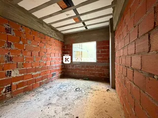 Ambiente interno com paredes de tijolo aparente e teto exposto.