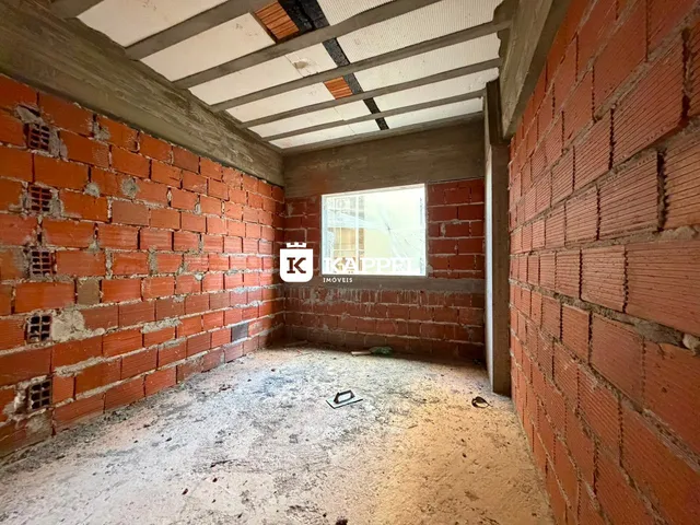 Ambiente interno com paredes de tijolo aparente e teto exposto.