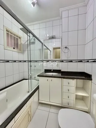 Foto interna de um banheiro com banheira e revestimento cerâmico.