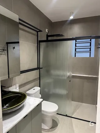 Foto de um banheiro moderno com revestimento de azulejos cinzas e box de vidro.