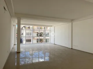 Interior de um espaço com piso polido e paredes brancas.