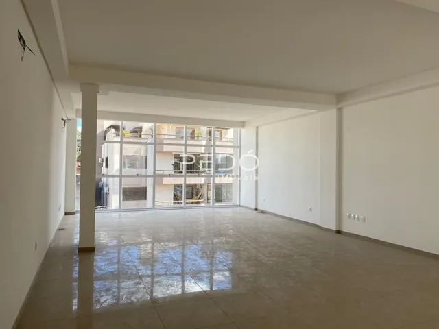 Interior de um espaço com piso polido e paredes brancas.