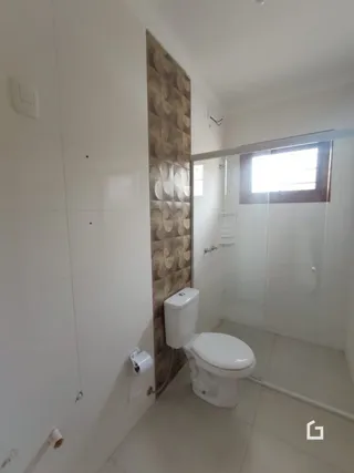 Foto de um banheiro interno com vaso sanitário e paredes claras.