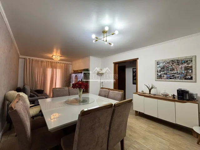 Sala de estar com mesa de jantar e cortinas em um imóvel no Brasil.