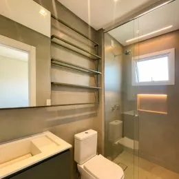 Foto de um banheiro interno com vaso sanitário e box de vidro.