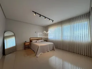 Quarto com cama e janela bem iluminada.