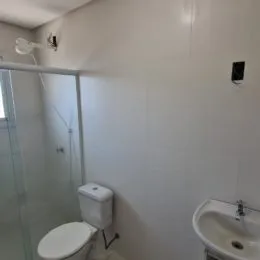 Foto de um banheiro interno mostrando o vaso sanitário e a pia.