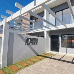 Fachada de uma residência em Lajeado, Brasil, mostrando uma área externa coberta com estrutura branca.