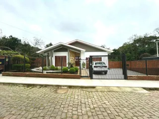 Fachada de uma casa em Lajeado, Brasil com cerca e portão de ferro.