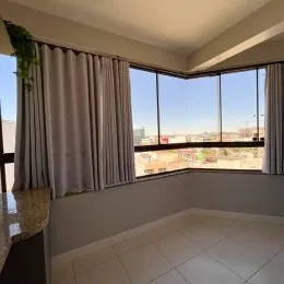 Vista de uma janela com cortinas em um ambiente interno com piso de cerâmica.