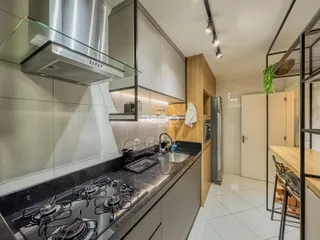 Cozinha moderna com armários de madeira e bancadas escuras.