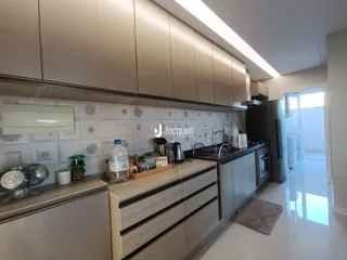 Cozinha moderna com armários e revestimento cerâmico.