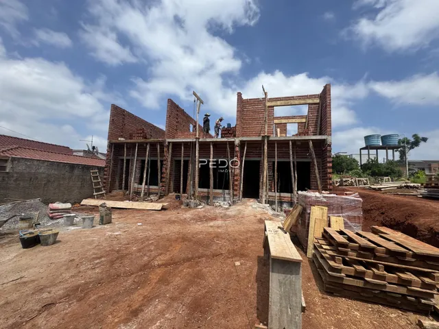 Estrutura de um edifício em construção com paredes de tijolo aparente.