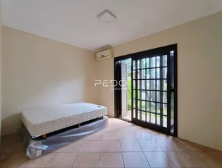 Quarto com cama e porta de vidro em um imóvel no Brasil.