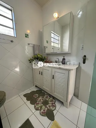 Cozinha com armários brancos e piso de cerâmica em ambiente interno.