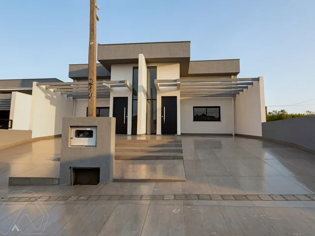 Fachada moderna de uma residência em Lajeado, Brasil, com revestimento branco e detalhes escuros.