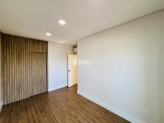 Interior de um ambiente com piso de madeira e parede de destaque.