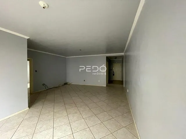 Corredor interno com piso de cerâmica claro.
