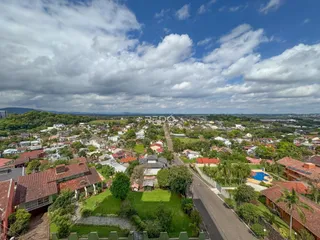 Vista aérea de um bairro residencial em Lajeado, Brasil, mostrando casas e áreas verdes.