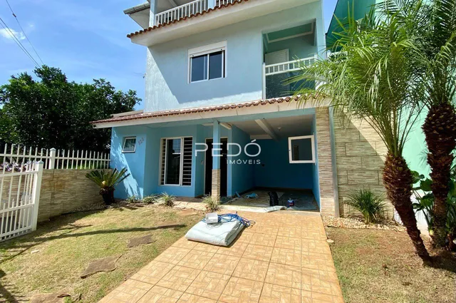 Fachada de uma casa em Lajeado, Brasil, com jardim e área externa pavimentada.