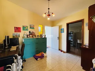 Sala de estar com paredes amarelas e piso de cerâmica clara.