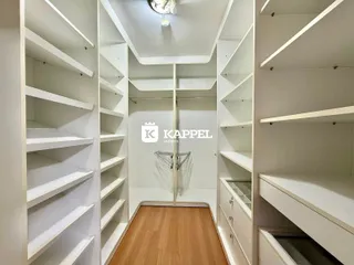 Hall de entrada com prateleiras brancas e piso de madeira clara.