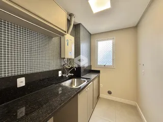 Cozinha com bancada escura e revestimento de azulejos brancos.