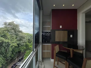 Vista interna de uma sala com parede vermelha e grande janela de vidro.