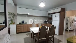 Uma sala de jantar com armários brancos e madeira na residência.