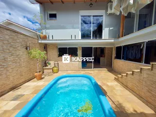 Foto da área externa com piscina e fachada de uma residência em Lajeado.