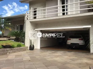 Fachada da residência mostrando a área de garagem coberta e o terraço.