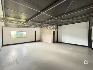 Vista interna de um ambiente amplo com teto de estrutura exposta.