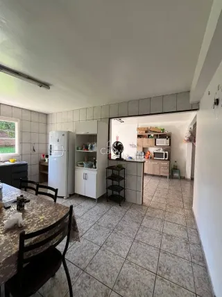 Foto de uma cozinha com armários brancos e piso de cerâmica.