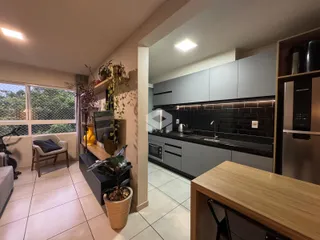 Sala de estar com vista para o jardim e cozinha moderna.