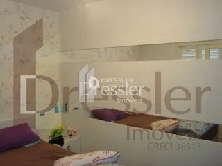Quarto com cama e espelho refletindo o ambiente.