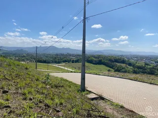 Vista panorâmica de paisagem com vegetação e colinas ao fundo.