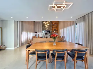 Sala de jantar com mesa de madeira e sofá em ambiente claro.