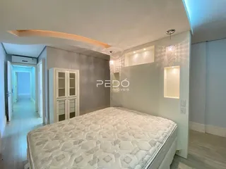 Quarto com cama grande e paredes cinzas em um imóvel no Brasil.