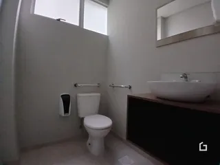 Foto de um banheiro interno com azulejos claros e vaso sanitário branco.