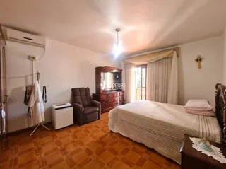 Quarto com cama e armário de madeira em um imóvel no Brasil.