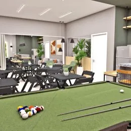 Ambiente interno com mesas e cadeiras em piso verde.