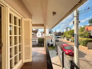 Vista externa da residência mostrando a entrada e a rua.